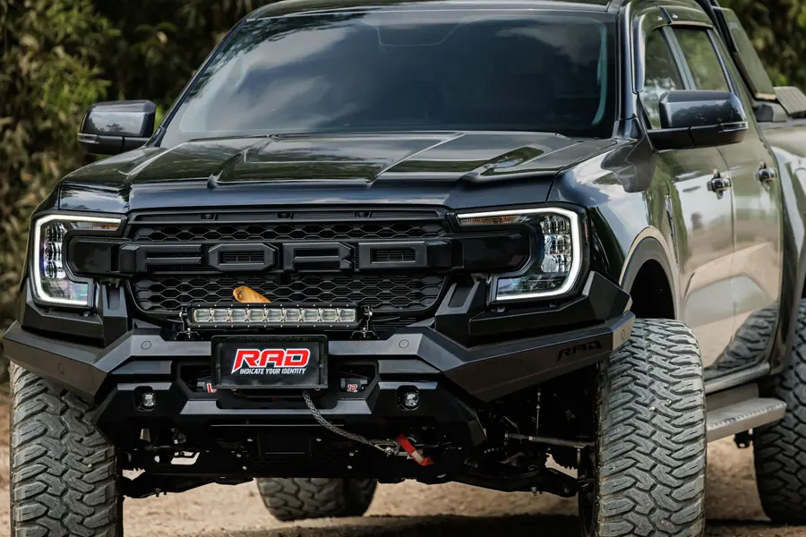 Lifted black off-road pickup truck parked on a dirt trail